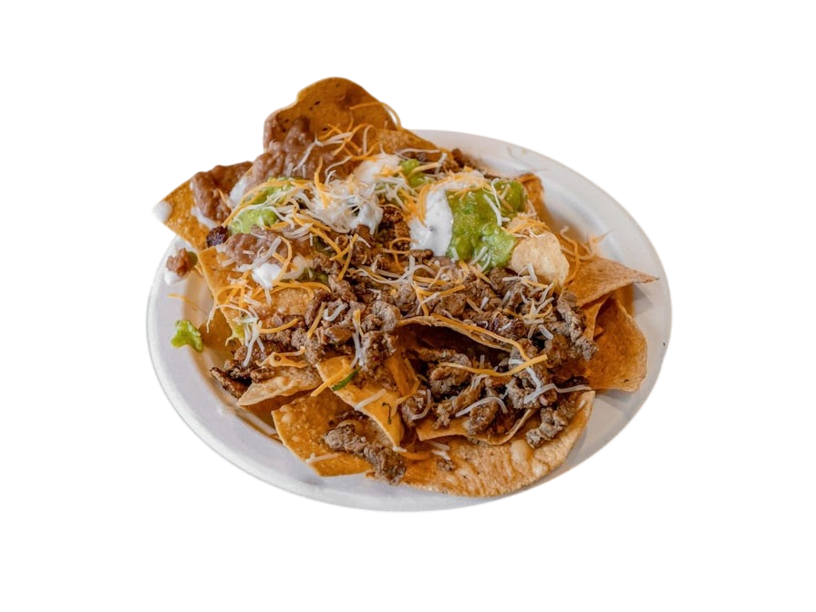 A plate of nachos topped with seasoned beef, melted cheese, guacamole, sour cream, and refried beans on a wooden surface. Warm and appetizing.